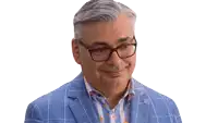 a man wearing glasses and a plaid jacket smiles