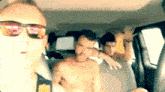 a man wearing sunglasses is taking a picture of himself and two other men in a car