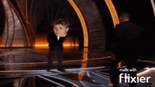 a man in a tuxedo is standing on a stage with the words made with flixier below him