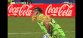 a soccer game is being played in front of a coca cola ad