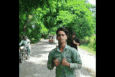 a young man wearing a green shirt with the name mr. jain on it