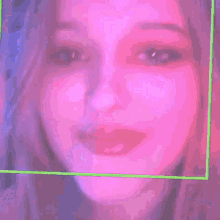 a close up of a woman 's face in a purple and green frame