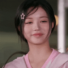 a girl with a pink star in her hair is smiling