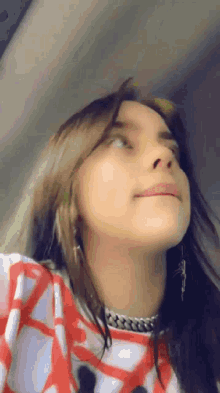 a close up of a woman 's face with her hair blowing in the wind while looking up .