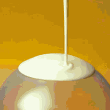 a glass filled with liquid is sitting on a tray next to a large ball of liquid
