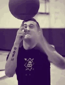 a man with a tattoo on his arm is balancing a basketball
