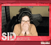 a woman wearing headphones covering her mouth with her hands in front of a sign that says sid @ greeksid