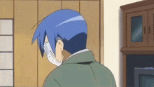 a man with blue hair is wearing a face mask in a living room .