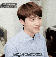 a young man is laughing and saying `` hahaha what is this '' while wearing a blue shirt .