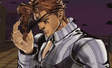 a man in a striped shirt is holding his hair in his hand .