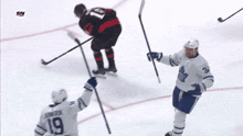 a hockey player with the number 19 on his back holds up his stick