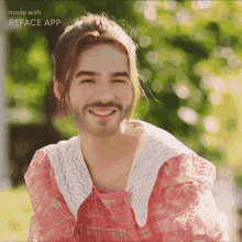a man with a beard wearing a pink dress is smiling