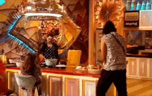 a woman is standing in front of a counter in a restaurant while a man is standing behind her .