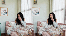 a woman is sitting on a bed with a picture on the wall above her