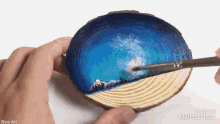 a person is painting a landscape on a piece of wood with the words wow art above it