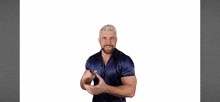 a man with a beard wearing a blue shirt is making a hand gesture