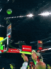 a basketball is going through a hoop with a sign that says state farm