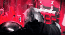 a man in a helmet is standing in a room with a red background .