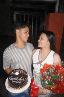 a man holds a cake that says congrats love