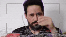 a man with a beard is holding a knife in front of his face