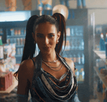 a woman with pigtails and a necklace stands in front of a vending machine