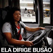 a woman driving a bus with the words " ela dirigie busao " on the bottom right