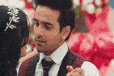 a man in a suit and tie is dancing with a woman in a dress