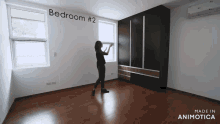 a woman stands in an empty bedroom with the words bedroom # 2 written on the wall