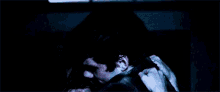 a man and a woman are sitting in a car in the dark .