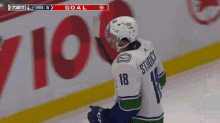 a hockey player with the number 18 on his jersey stands on the ice