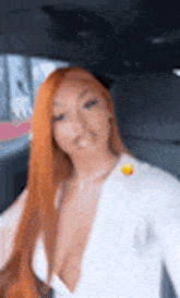 a woman with long red hair is sitting in the back of a car .