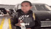 a young boy wearing an all star sweatshirt is holding a bottle of water