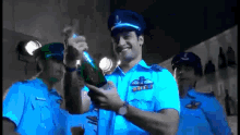 a man in a blue uniform is holding a bottle