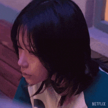 a close up of a person 's face with a netflix logo on the bottom right .