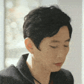 a close up of a man 's face with his eyes closed wearing earrings