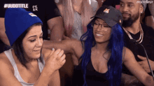 a woman with blue hair wearing glasses and a black hat with a cat on it