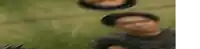 a blurry picture of a man standing in the grass with a sword .