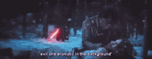 a man is laying in the snow with a red light saber in the background and says `` evil and dramatic in the background '' .