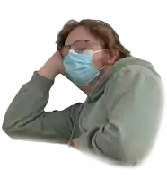 a man wearing a face mask and glasses looks tired