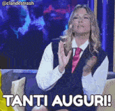 a woman sitting on a couch with the words tanti auguri written on the bottom
