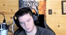 a man wearing headphones and a microphone with the word nice above him
