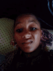 a young girl is smiling while laying on a couch