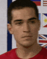 a man in a red shirt is looking at the camera