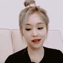 a woman with a bun on her head is sitting on a couch