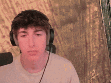 a man wearing headphones and a white shirt looks at the camera