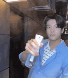 a man in a blue jacket holds a spray bottle