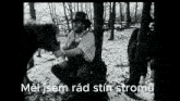a black and white photo of a man sitting next to a tree with the words " mel jsem rad stin stromu " written below him