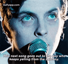 a man singing into a microphone with the words this next song goes out to the guy who keeps yelling from the balcony below