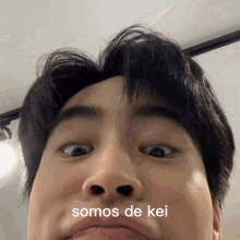 a close up of a man 's face with the words somos de kei above his mouth