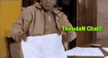 a woman is sitting at a table holding a piece of paper that says thirutan chat